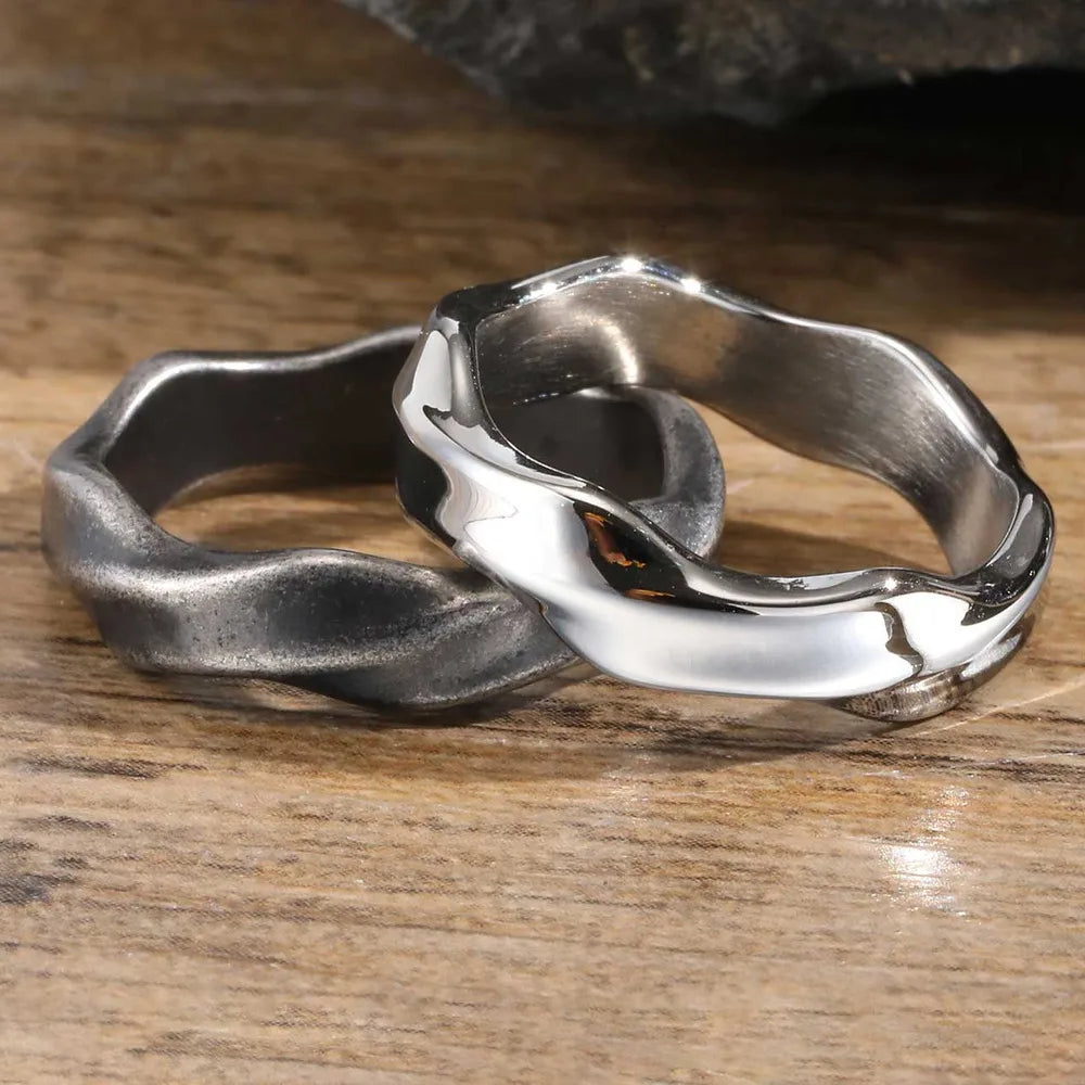 Two oxidized and polished Mobius band rings on a wooden surface
