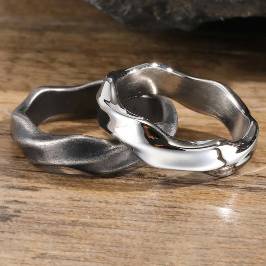Two oxidized and polished Mobius band rings on a wooden surface