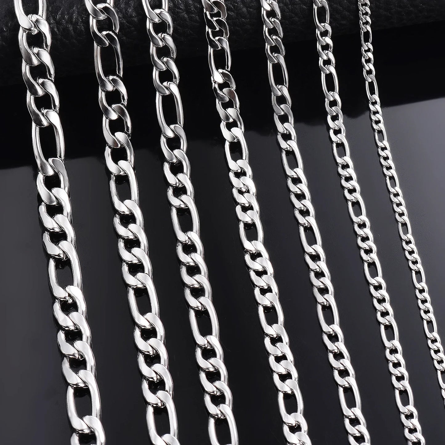 Silver-tone chain necklace width options on dark background