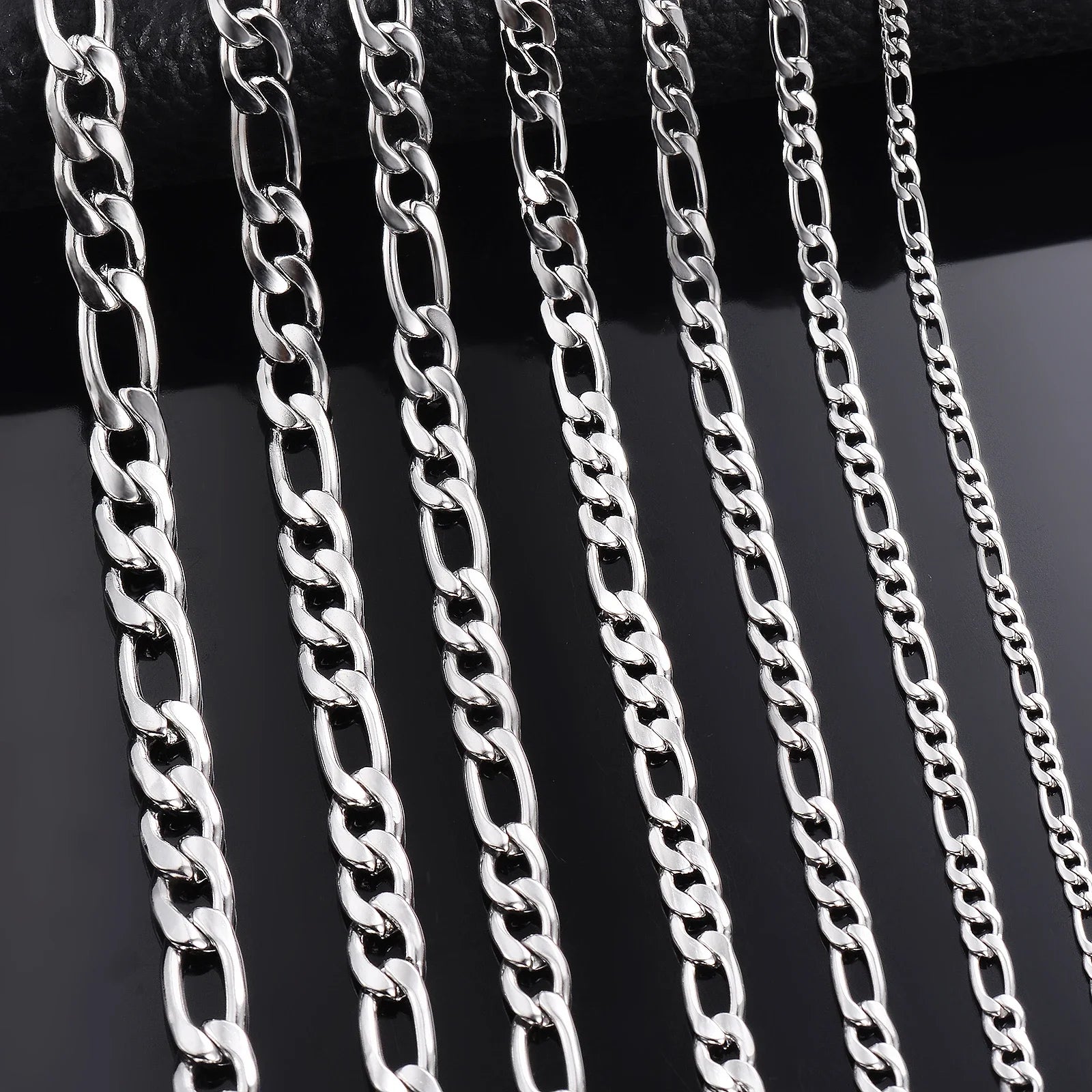 Silver-tone chain necklace width options on dark background